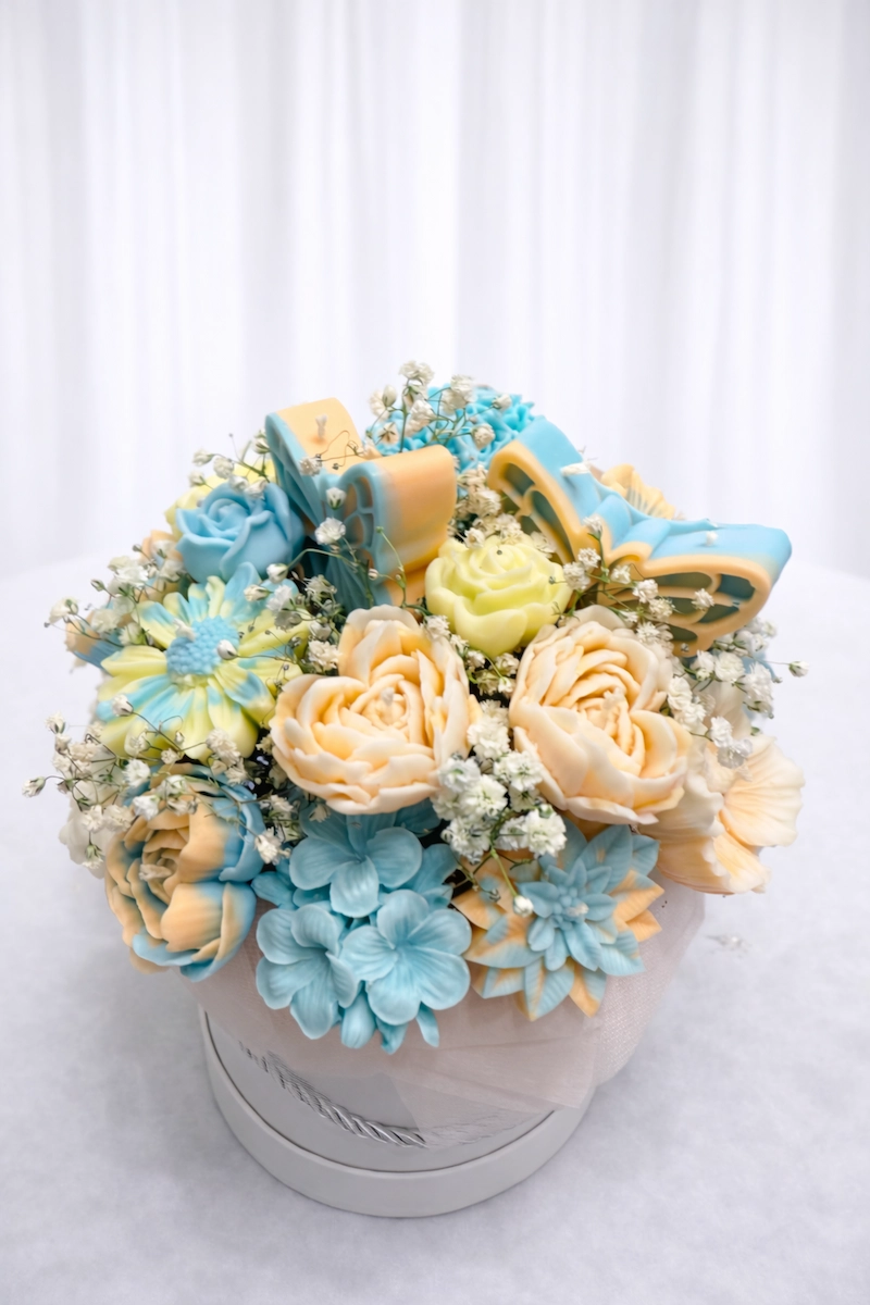 Mėlynos ir geltonos spalvų sojų vaško žvakių puokštė elegantiškoje dėžutėje
